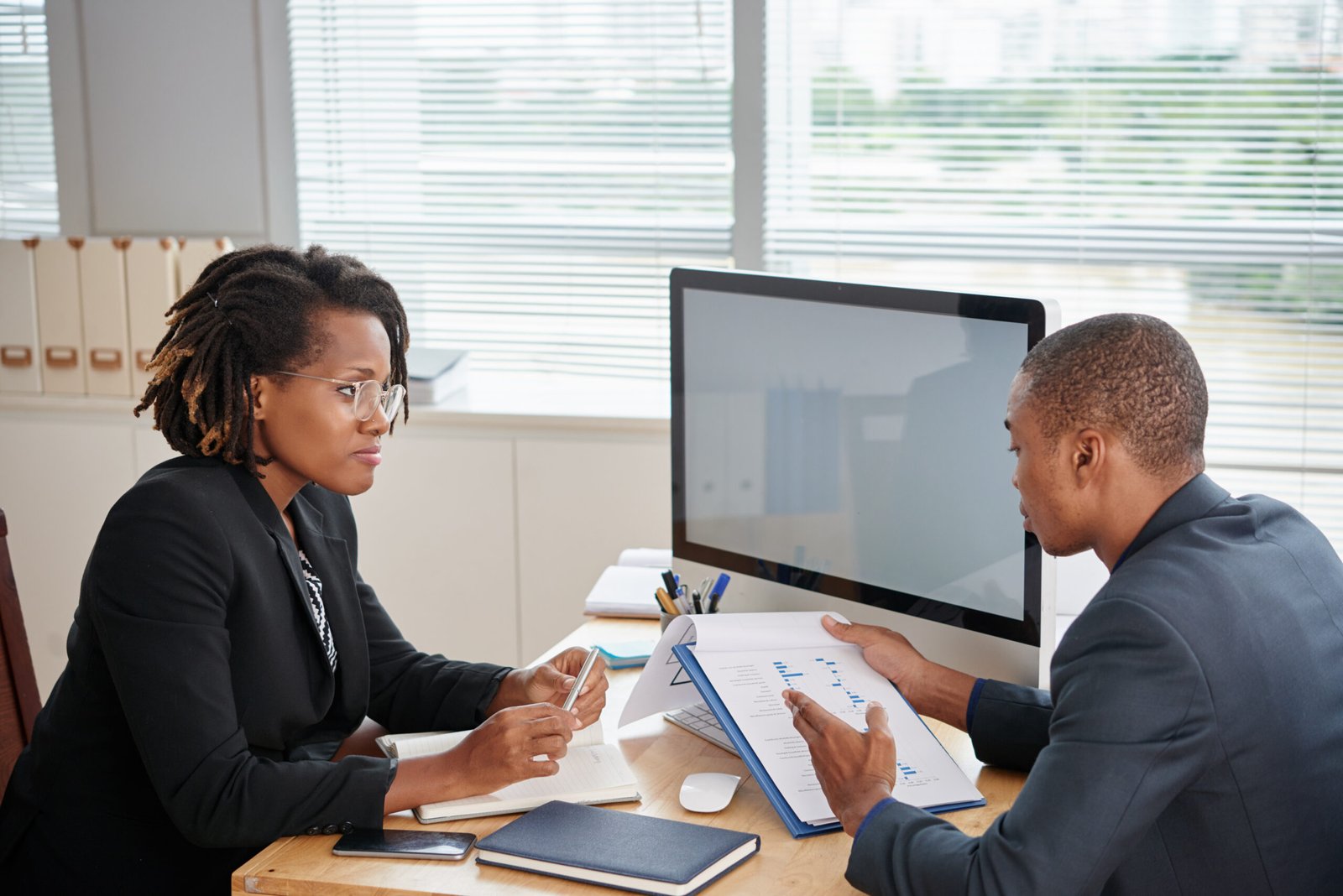 Female entrepreneur listening to report of financial manager